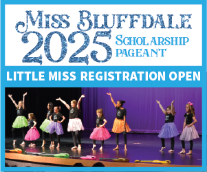 Nine girls in brightly colored skirts on stage